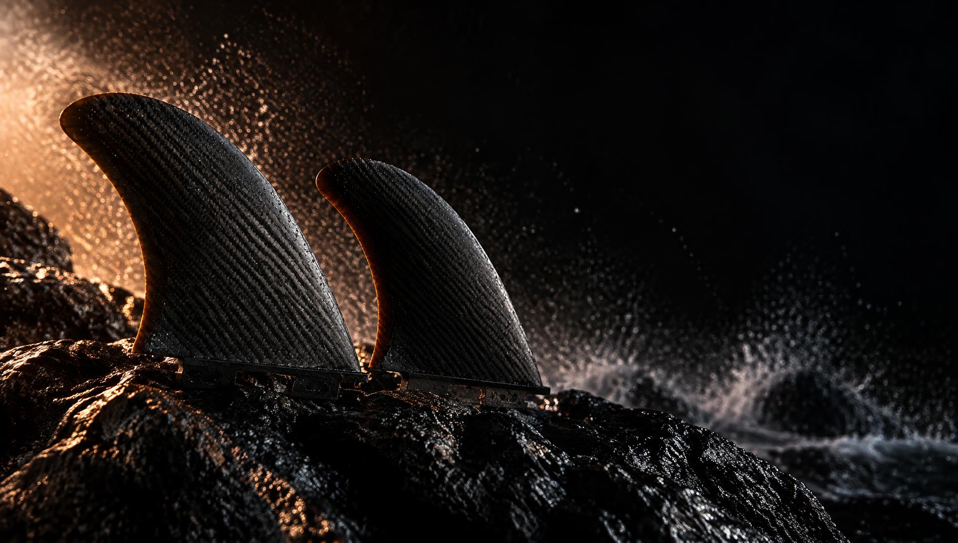 Carbon surfboard fins on wet volcanic rock
